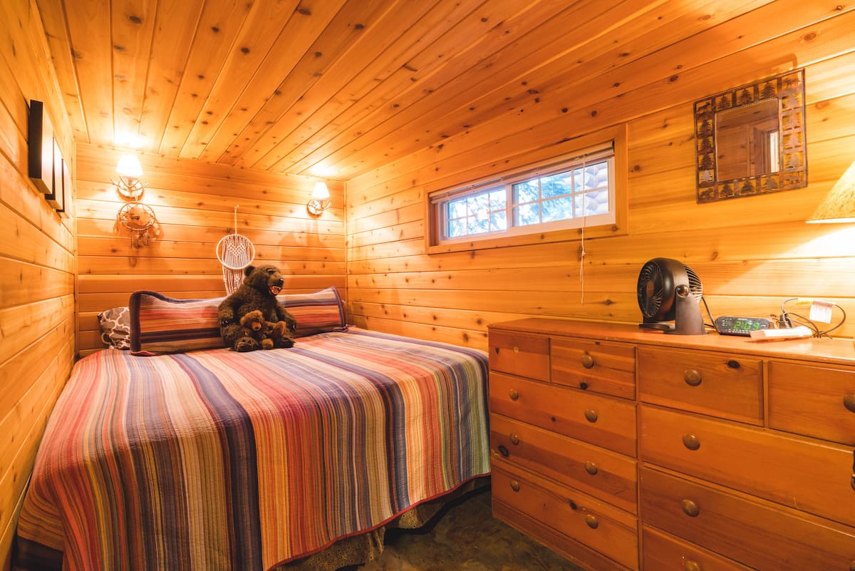 Downstairs bedroom with a king bed and wooden dresser